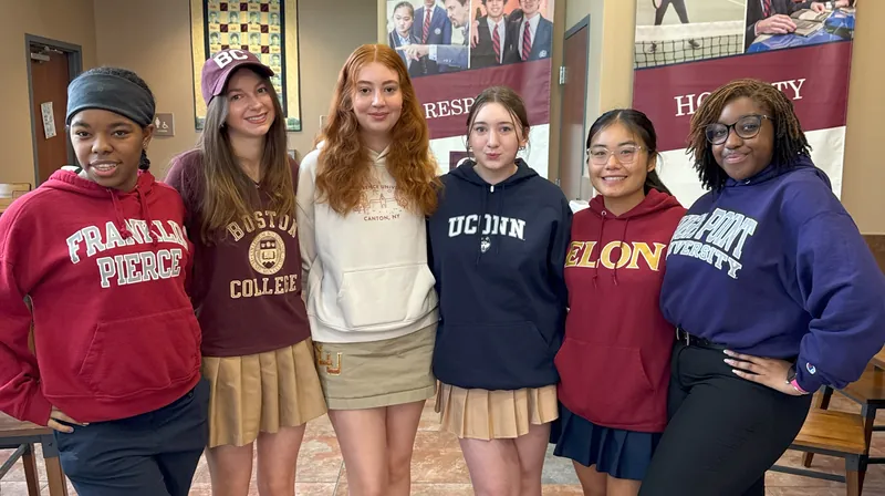 Six Gow students smile together in college sweatshirts from Franklin Pierce, Boston College, St. Lawrence, UConn, Elon and High Point