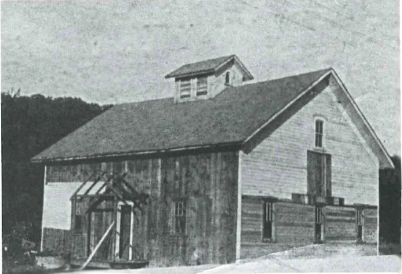 The original horse barn that became the Main Building, in an early photograph