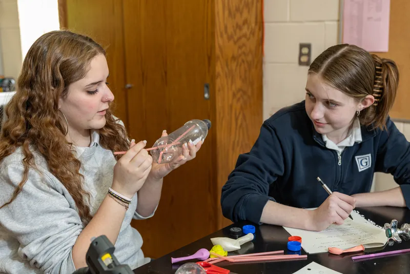 Two upper school students working on a hands-on project together at a classroom table