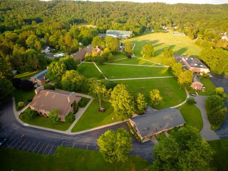 Aerial view of the Gow campus today: rooftops among trees in the valley